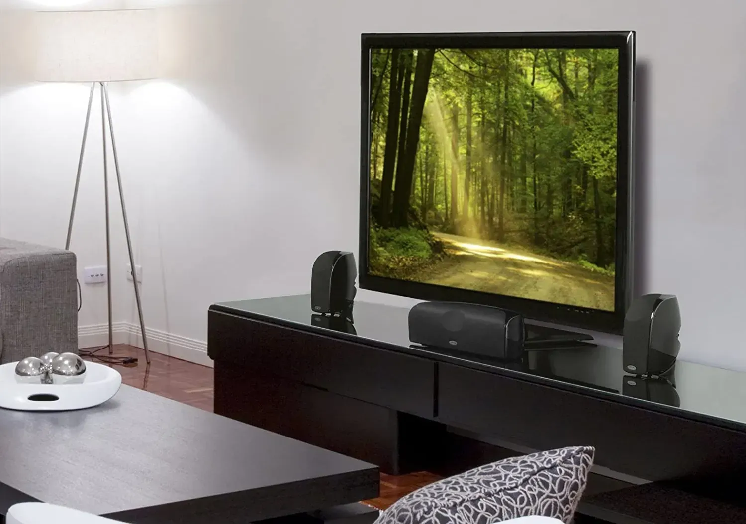Living room TV on a black media stand with surround sound speakers