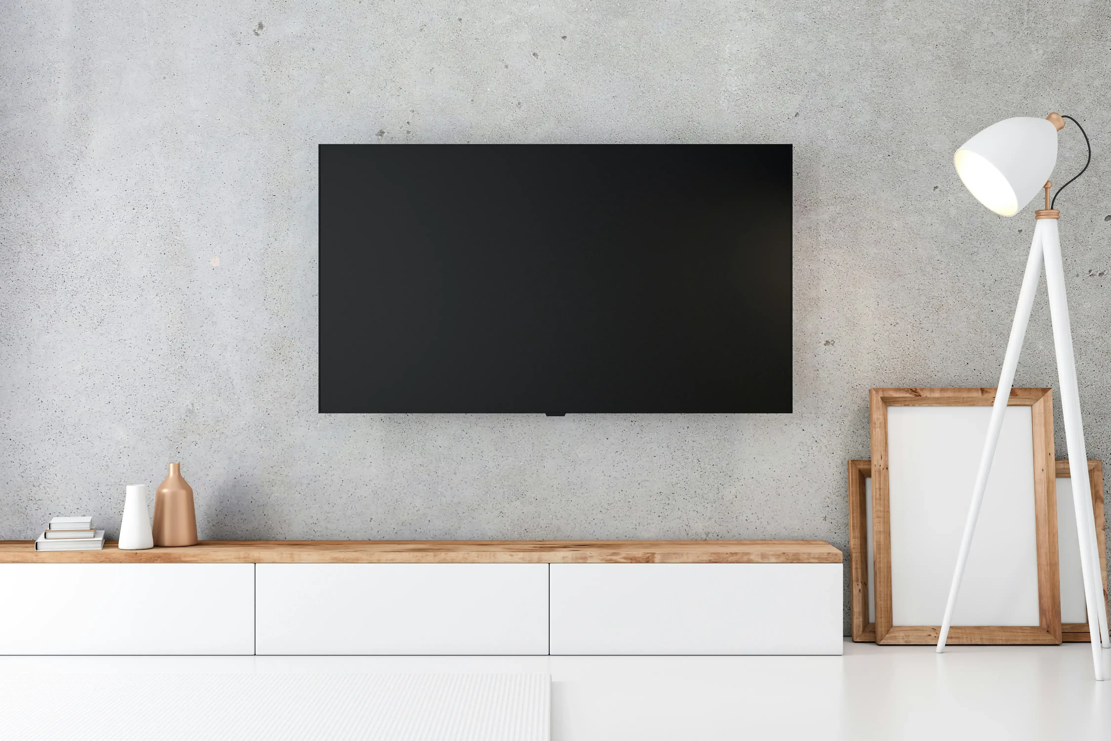 Flat-screen TV mounted on a gray concrete wall above a white media console